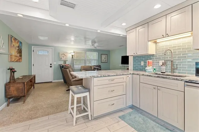 a kitchen with a dining table chairs cabinets and stainless steel appliances