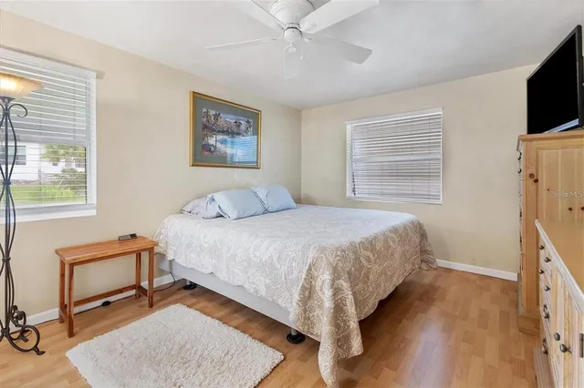 a bedroom with a bed a dresser and flat screen tv
