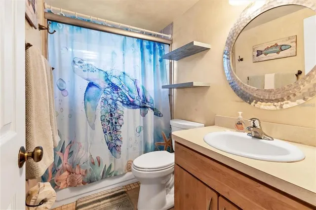 a bathroom with a sink a mirror a toilet and a shower curtain