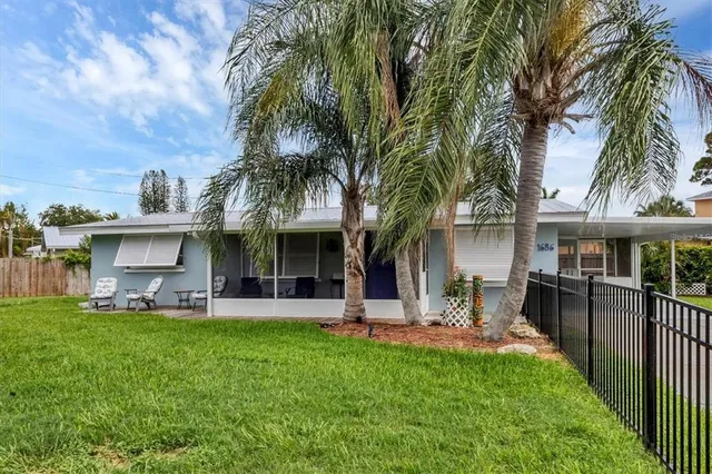 a view of a house with a yard and sitting area