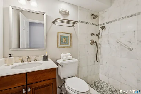 a bathroom with a sink toilet vanity and shower