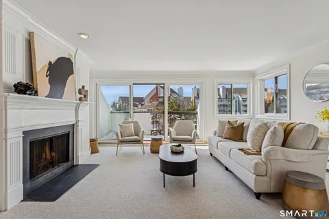 a living room with furniture large window and fireplace