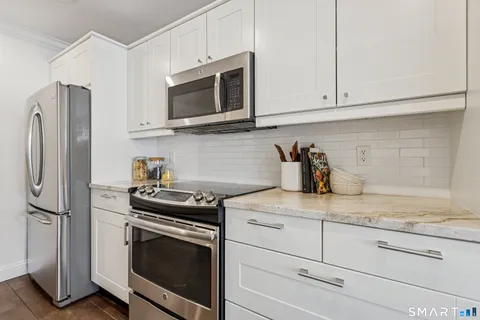 a kitchen with granite countertop white cabinets stainless steel appliances and sink