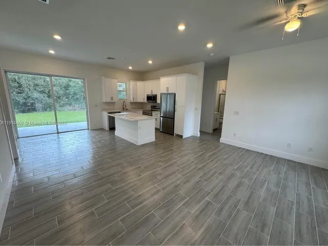 a view of a kitchen with furniture and wooden floor