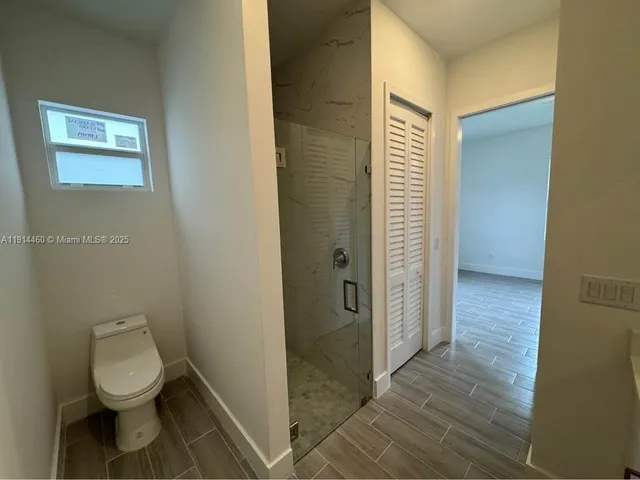 a bathroom with a toilet and a shower