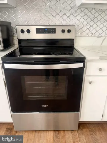 a kitchen with granite countertop stainless steel appliances a sink and a stove