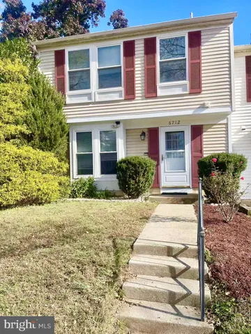 a front view of a house with plants