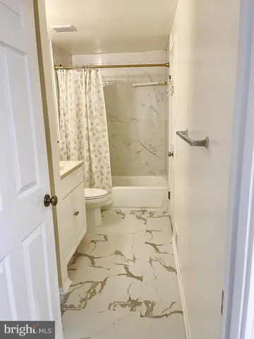 a view of a room with wooden floor and a window