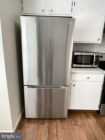 a utility room with wooden floor washer and dryer
