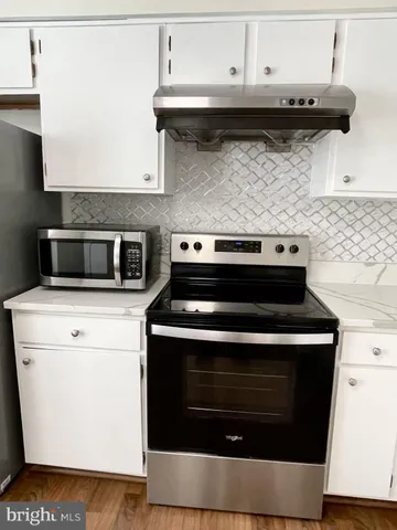 a stove top oven sitting inside of a kitchen