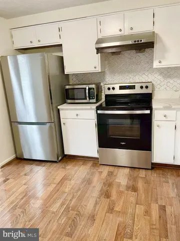 a kitchen with a stove a microwave and a refrigerator