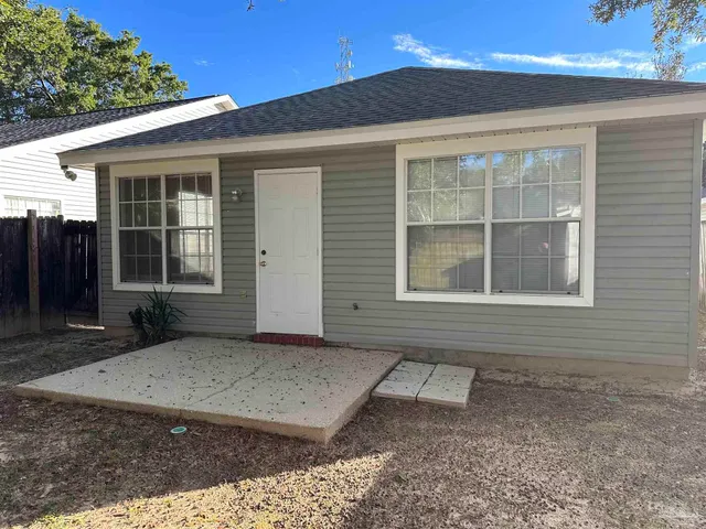 a view of a yard with wooden fence and a tree