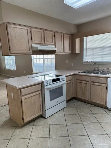 a kitchen with a stove sink and cabinets