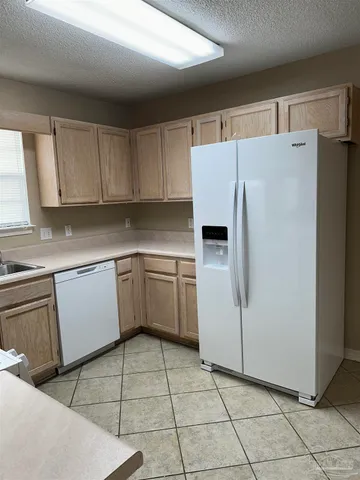 a white refrigerator freezer sitting inside of a kitchen with stainless steel appliances granite countertop a refrigerator sink and cabinets