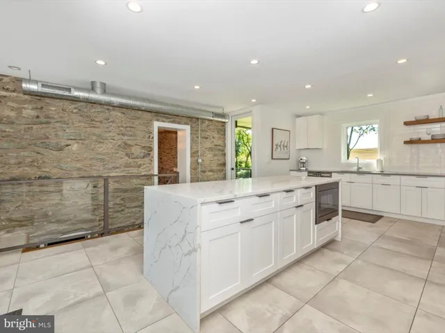 a kitchen with white cabinets and sink