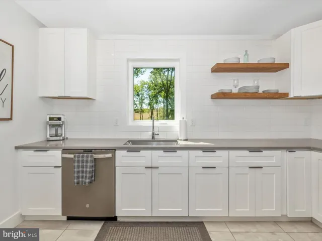 a bedroom with a bed a mirror on dresser and a window