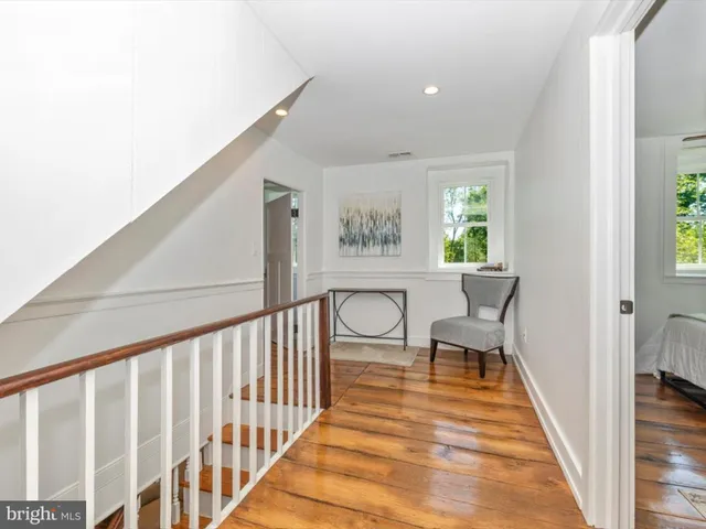 a view of a backyard with lawn chairs potted plants and a large tree