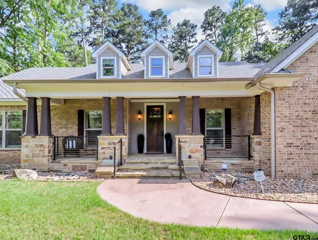 a front view of a house with garden and outdoor seating