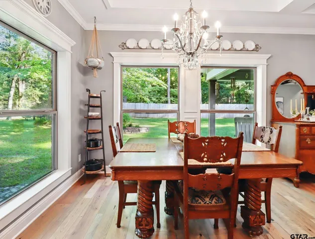 a view of a dining room with furniture a chandelier and wooden floor