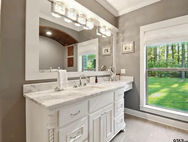 a bathroom with a sink vanity and a mirror