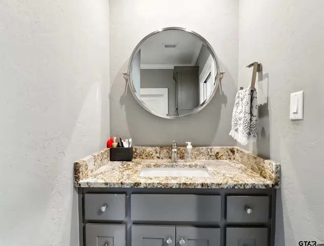 a bathroom with a granite countertop sink and a mirror