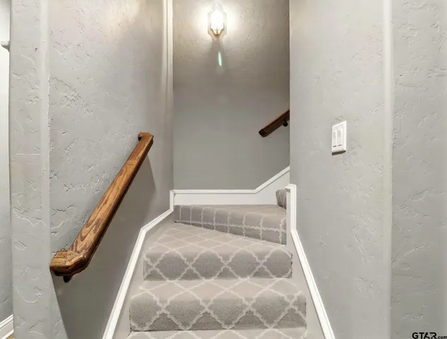 a view of staircase with rug