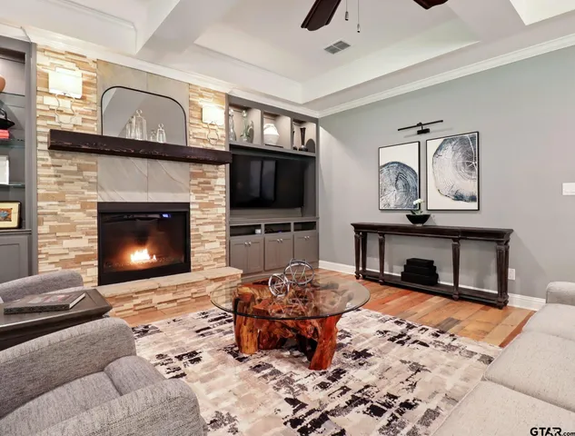 a living room with furniture a fireplace and a flat screen tv