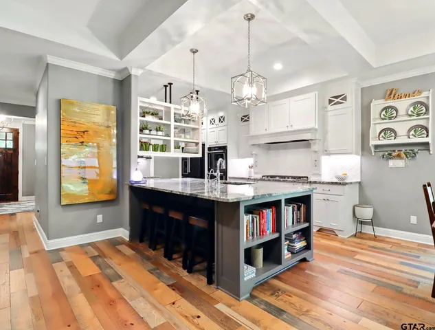 a kitchen with stainless steel appliances granite countertop a stove and a wooden floors