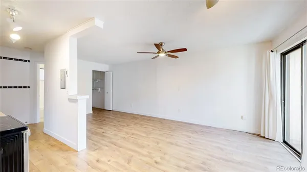a view of a livingroom with a ceiling fan and refrigerator