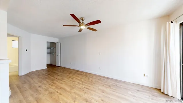 a view of a livingroom with a ceiling fan and refrigerator