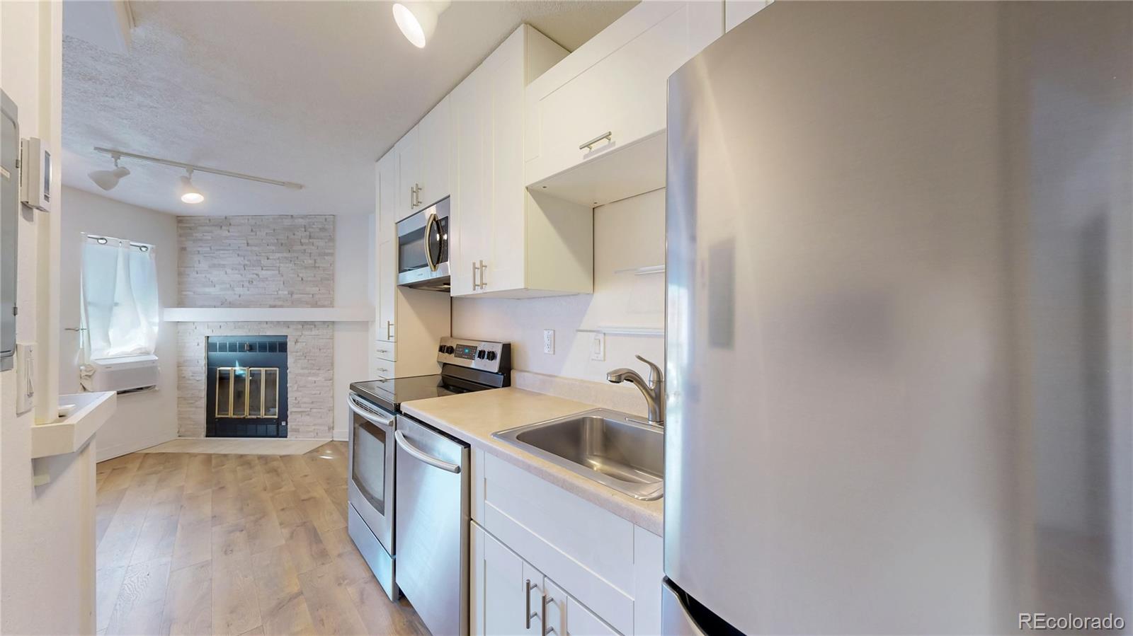 1934 18th Street, Unit 8 Boulder, CO 80302 - Photo 10 of 41 a kitchen with a sink stove top oven and cabinets