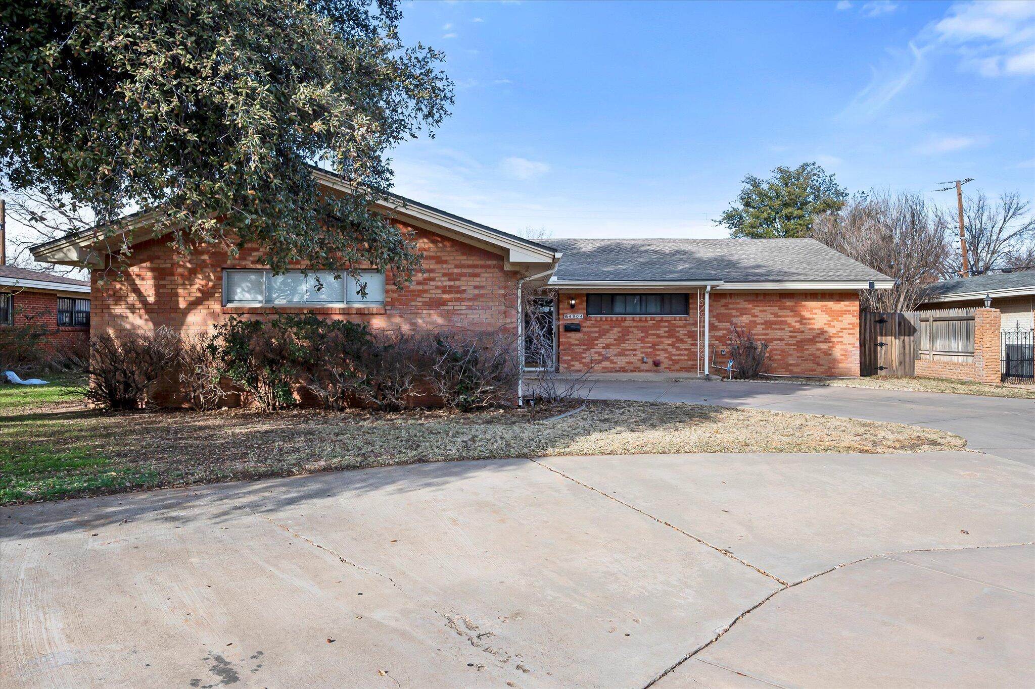 4904 15th Street Lubbock, TX 79416 - Photo 1 of 29 a front view of a house with a yard and garage