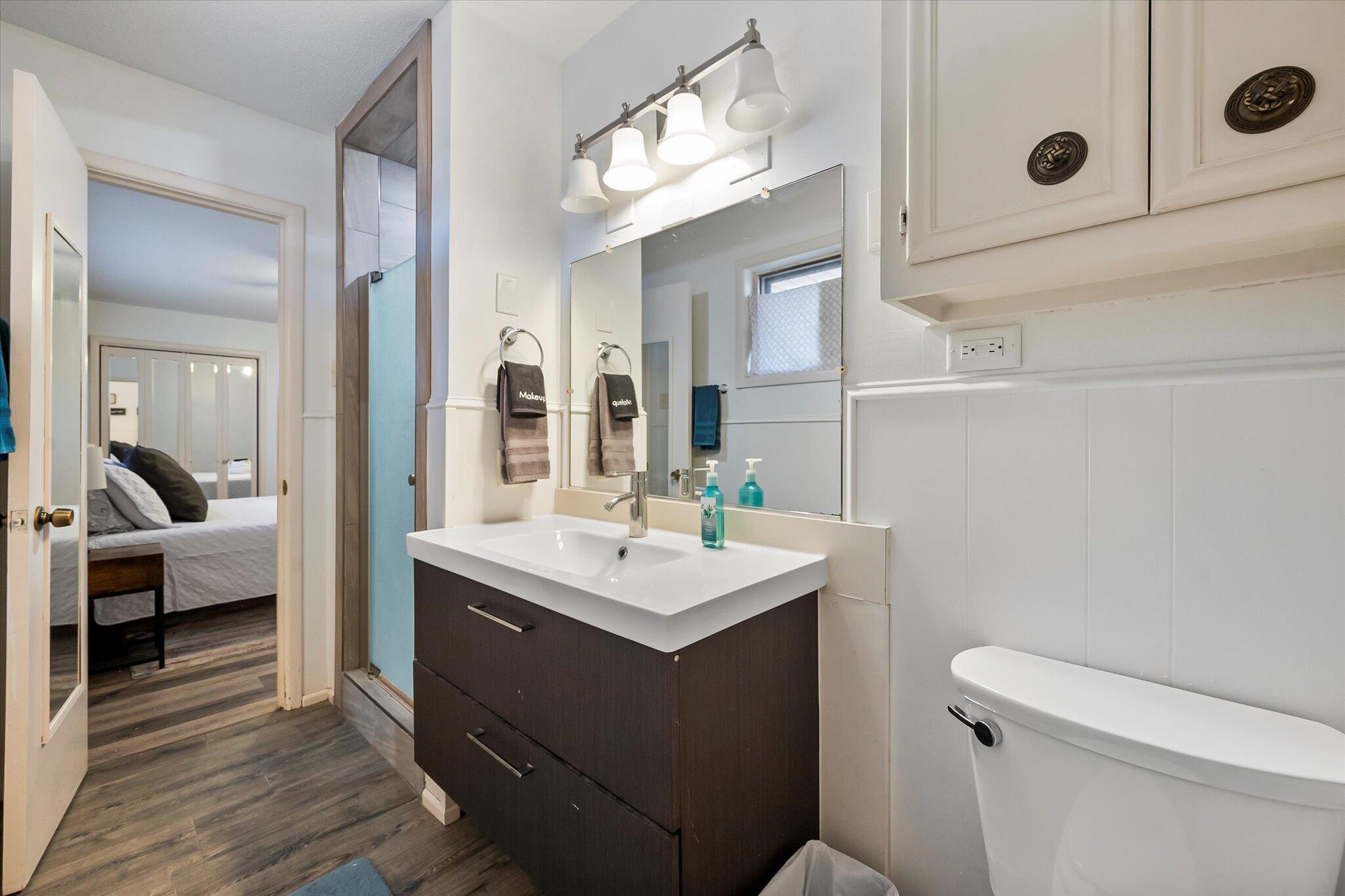 4904 15th Street Lubbock, TX 79416 - Photo 12 of 29 a bathroom with a sink a toilet a mirror and shower