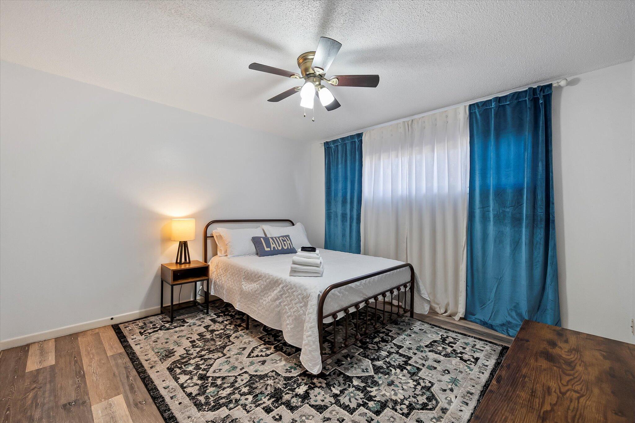 4904 15th Street Lubbock, TX 79416 - Photo 13 of 29 a bedroom with a bed and a chandelier