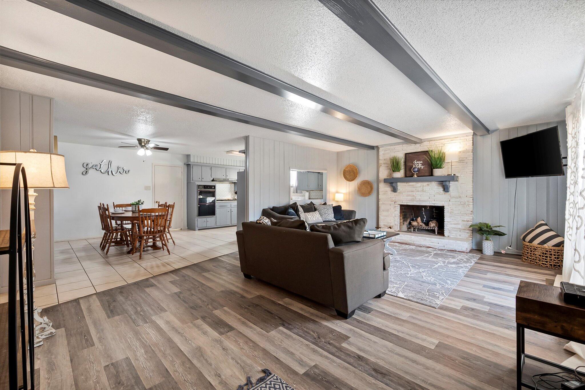 4904 15th Street Lubbock, TX 79416 - Photo 15 of 29 a living room with furniture a fireplace and a flat screen tv