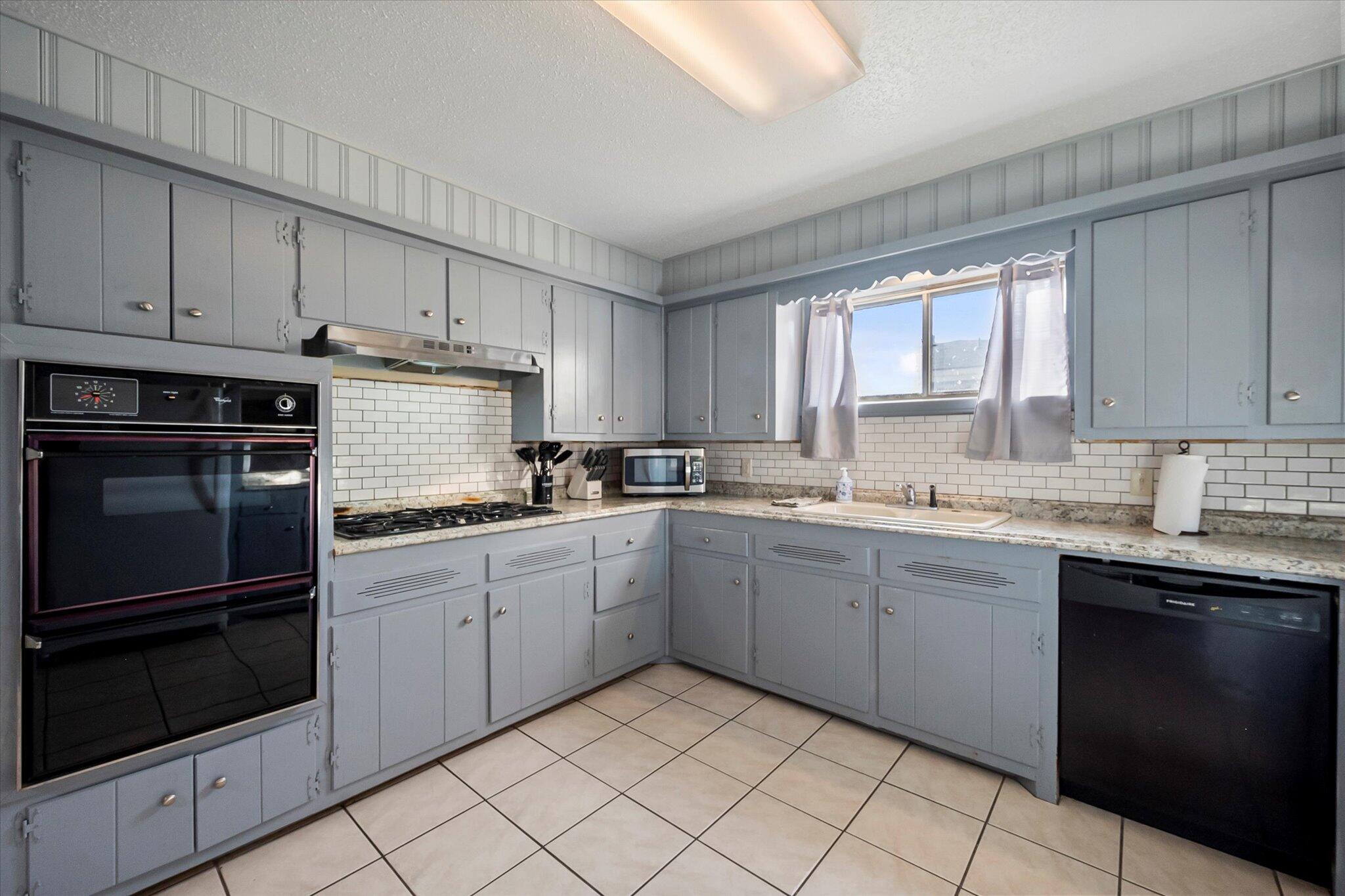 4904 15th Street Lubbock, TX 79416 - Photo 24 of 29 a kitchen with granite countertop white cabinets and white appliances