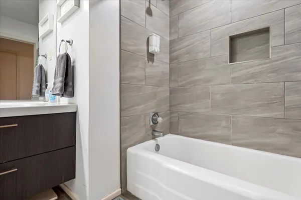 a bathroom with a tub a sink a window and a shower