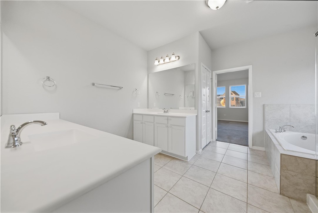 4316 Mocking Run Lane Dickinson, TX 77539 - Photo 14 of 24 a spacious bathroom with a sink a mirror and a bathtub