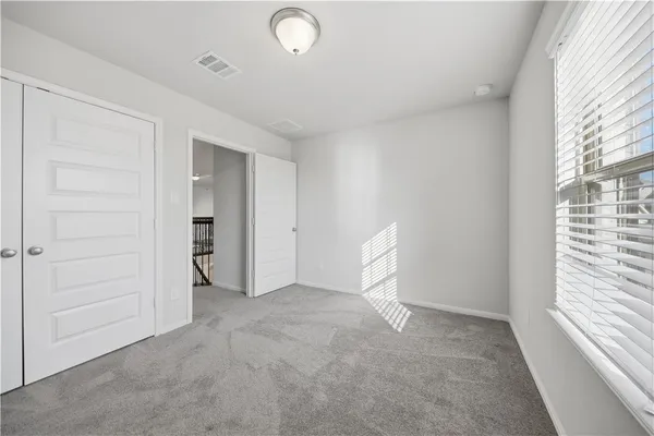 an empty room with closet and windows