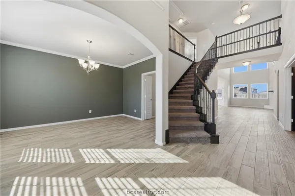 a view of a hallway with wooden floor and staircase
