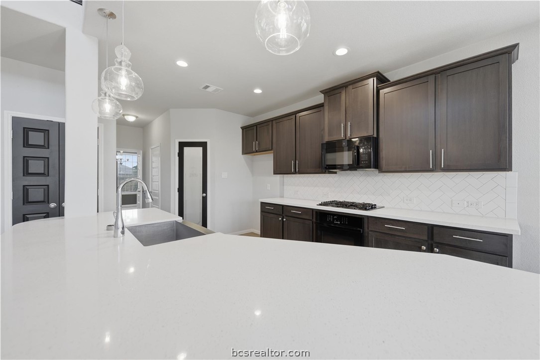 4316 Mocking Run Lane Dickinson, TX 77539 - Photo 8 of 24 a large white kitchen with a large counter top space appliances and cabinets