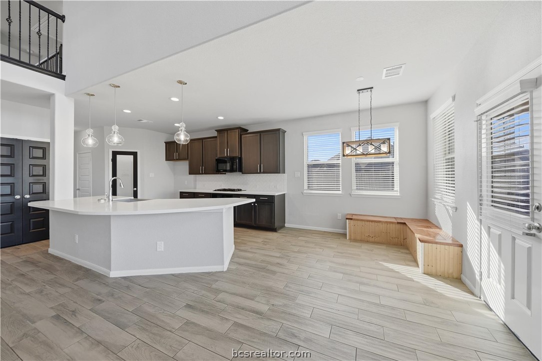 4316 Mocking Run Lane Dickinson, TX 77539 - Photo 9 of 24 a large kitchen with stainless steel appliances kitchen island granite countertop a large counter top and a wooden floors