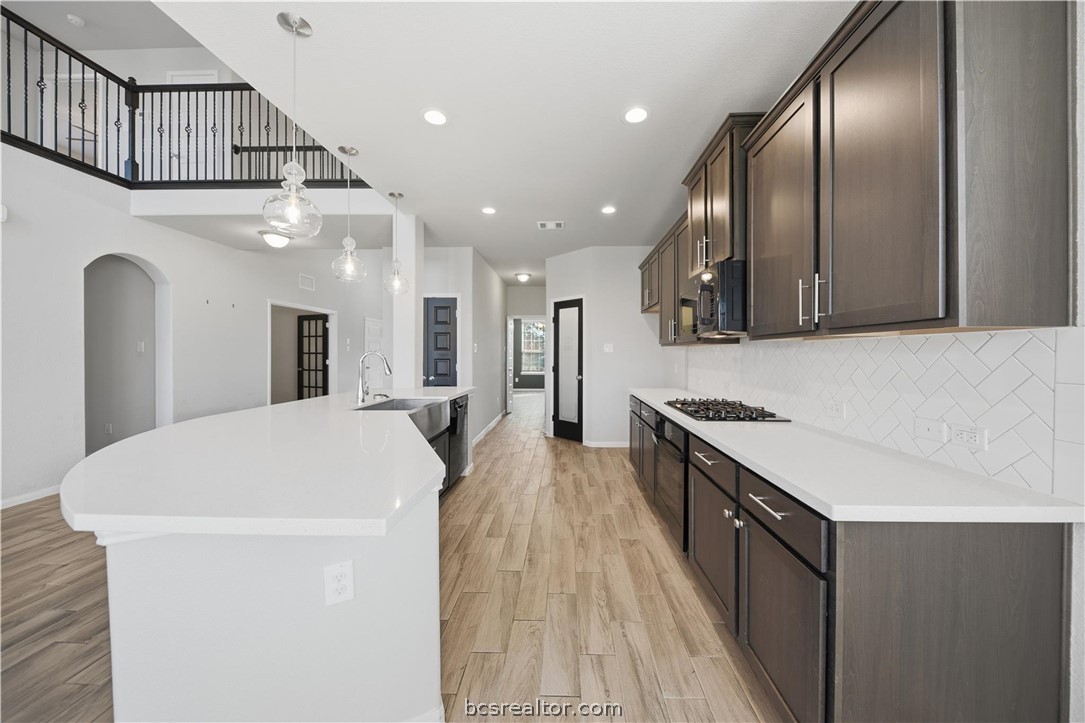 4316 Mocking Run Lane Dickinson, TX 77539 - Photo 10 of 24 a large kitchen with stainless steel appliances a large counter top a stove and a refrigerator