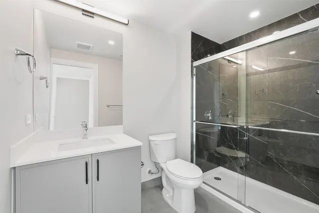 a bathroom with a sink a toilet and shower