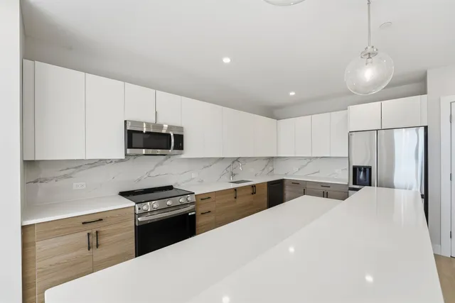a kitchen with granite countertop a sink a stove and refrigerator