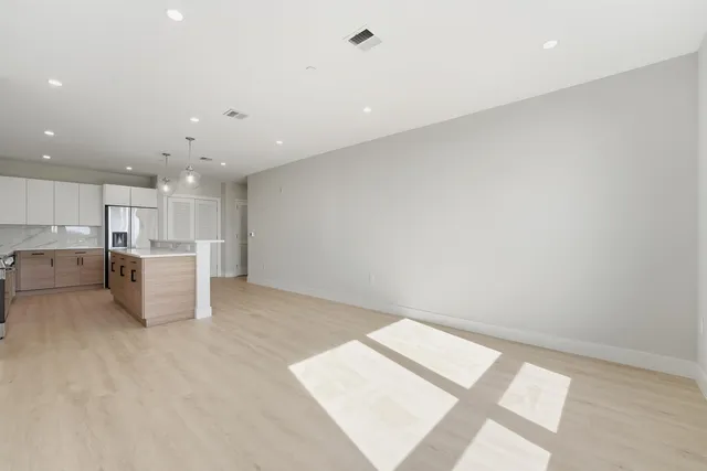 a view of an empty room with kitchen