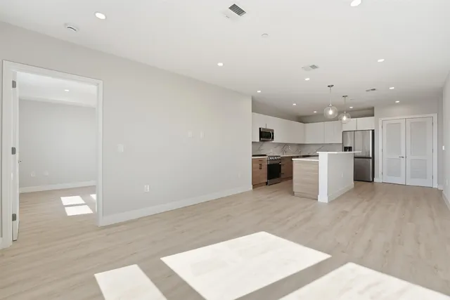 a large white kitchen with cabinets