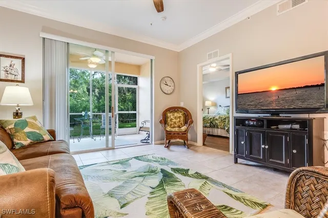 a living room with furniture a flat screen tv and floor to ceiling window