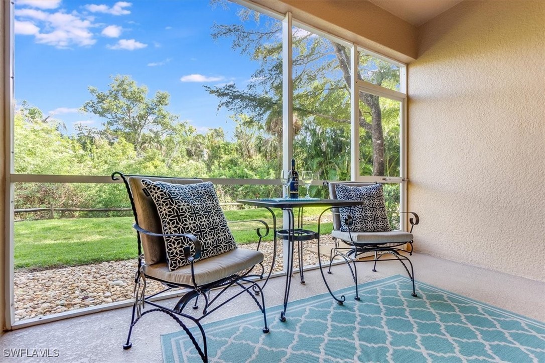 8251 Pathfinder Loop, Unit 615 Fort Myers, FL 33919 - Photo 19 of 44 a view of a chairs and table in patio with a yard