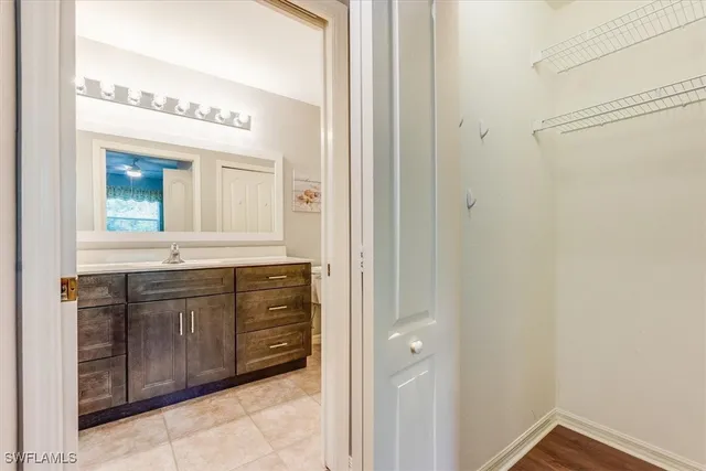 a bathroom with a granite countertop sink two mirror and a vanity